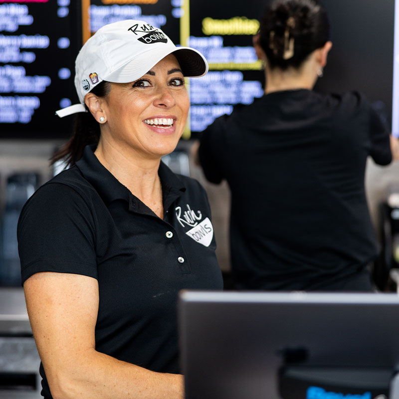 A Rush Bowls worker ready to help you enjoy all the goodness that our acai franchise has to offer!